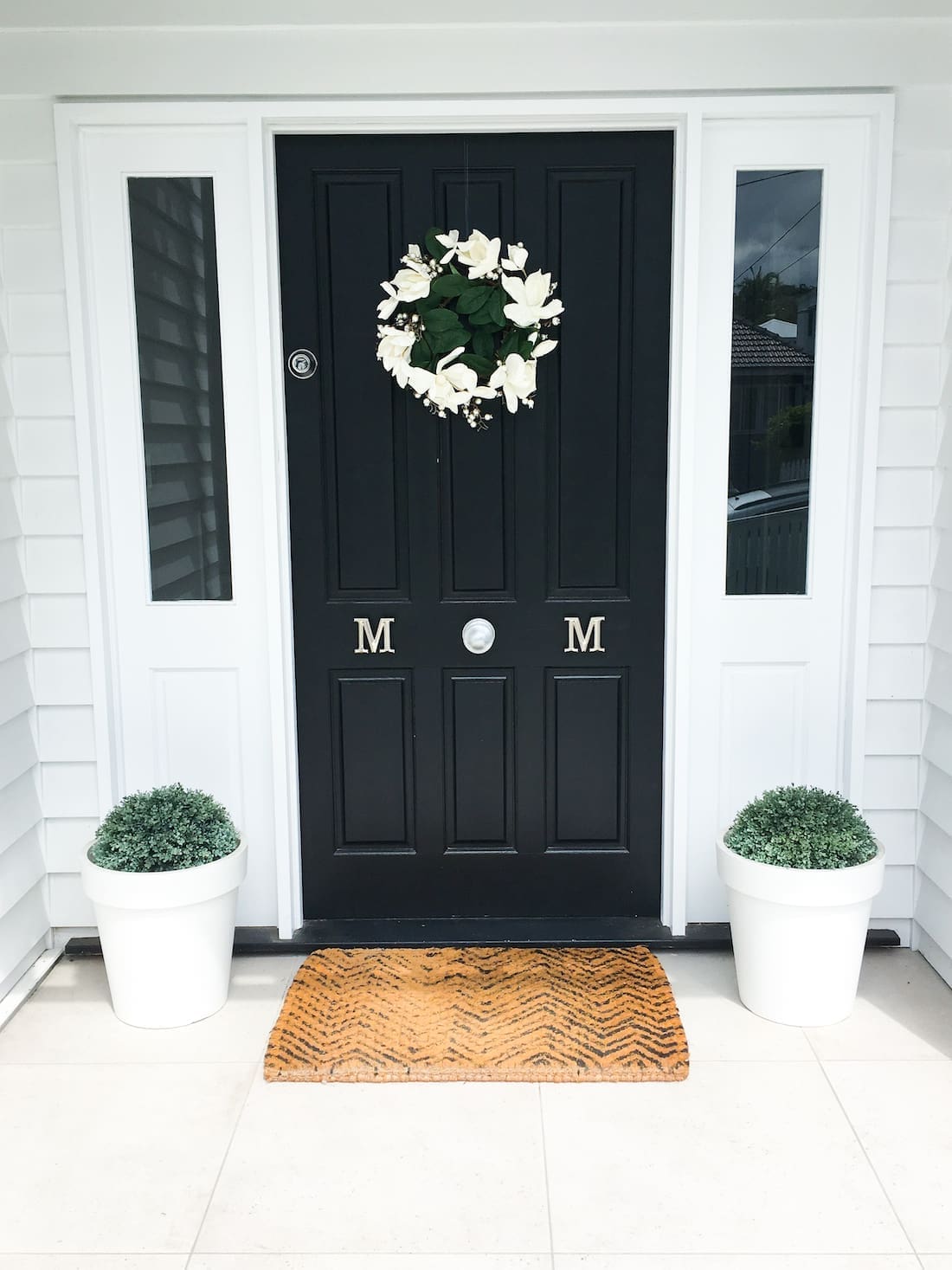 Black front door with magnolia wreath