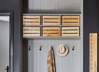 Grey mudroom with wooden boxes for storage in garage and wooden height chart