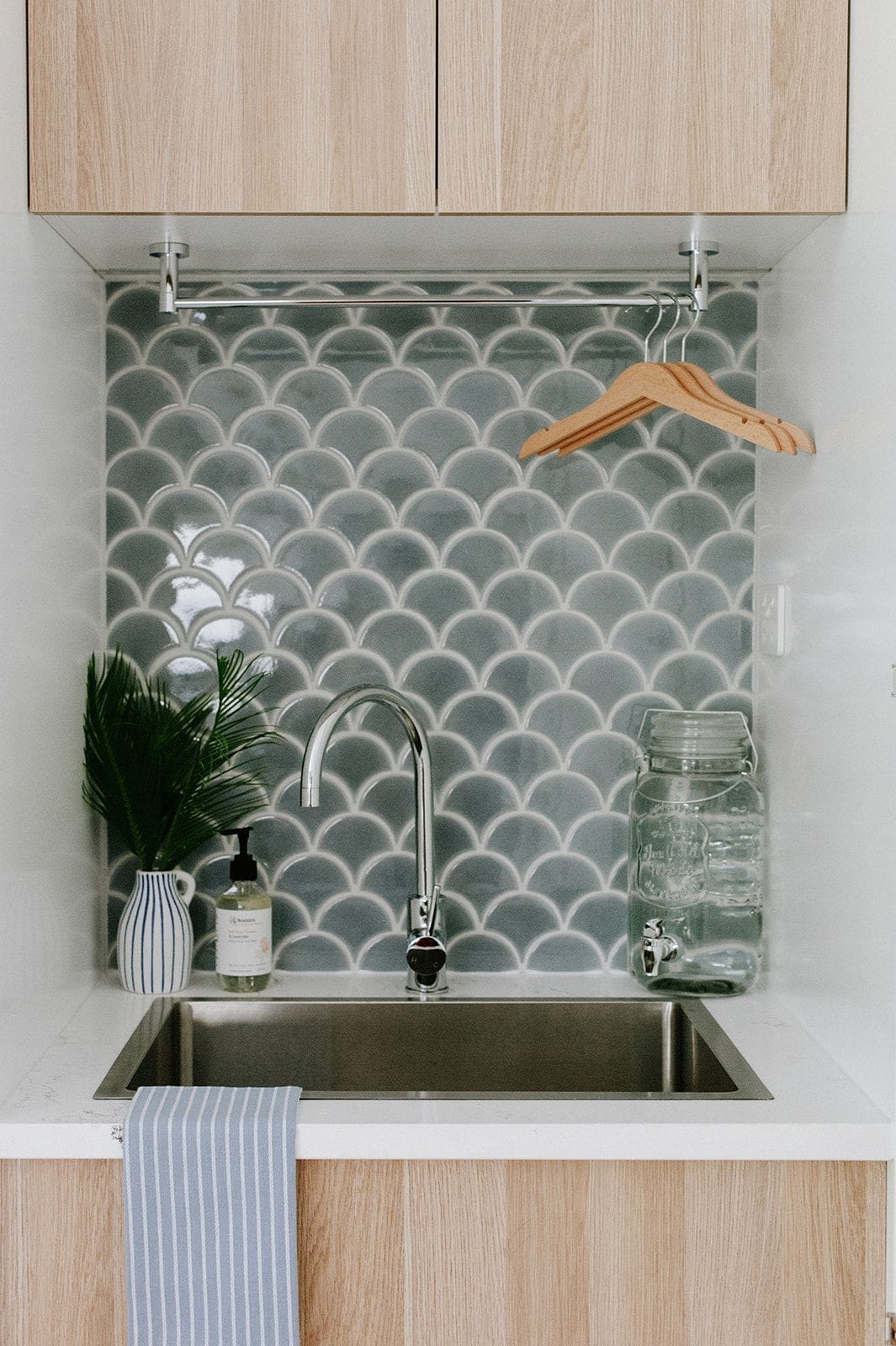 Under-stair laundry with green fishscale tile