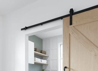 Laundry with panelling, green wall and sliding barn door