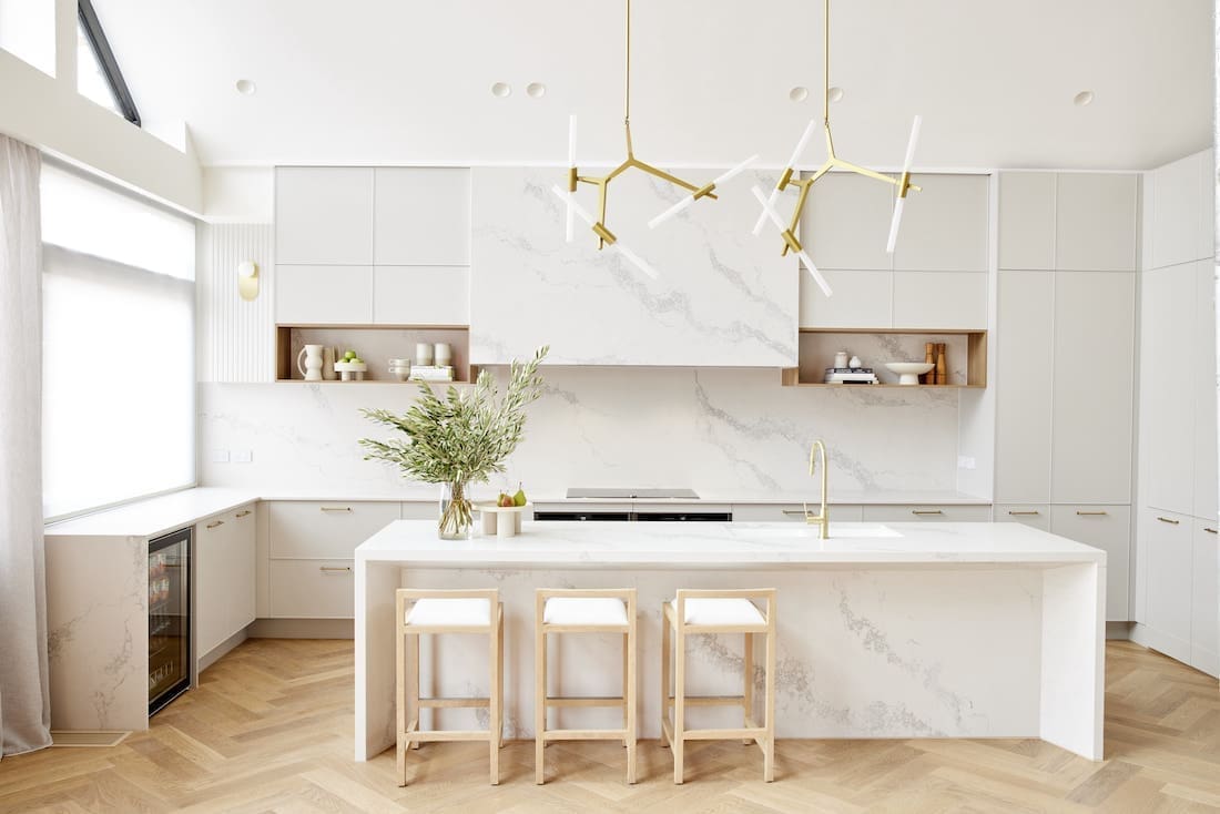 White stone kitchen with gold bar chandelier