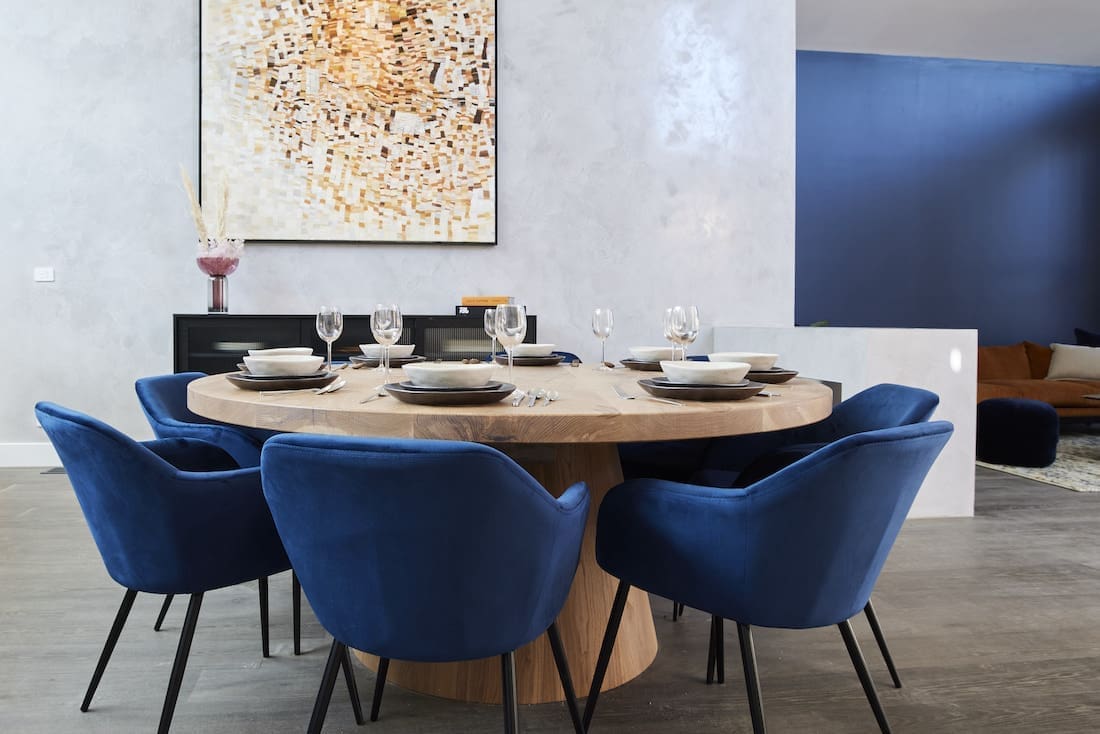 Christian Cole round dining table with blue velvet chairs