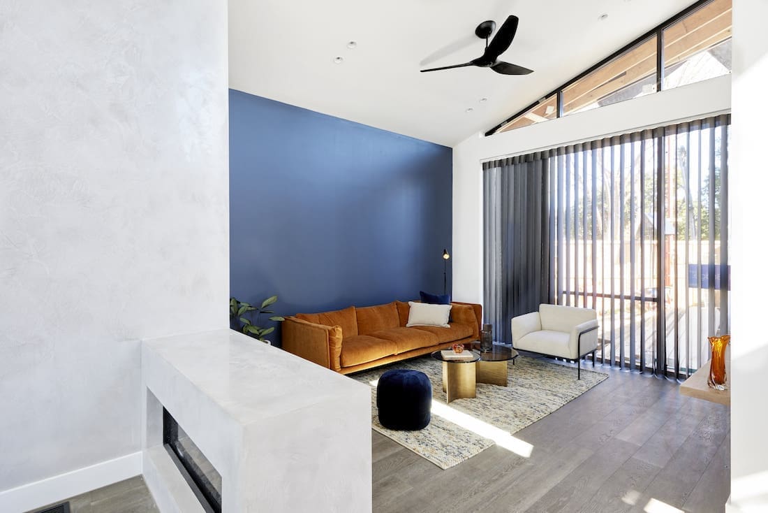 navy wall in living room with black sheer curtains