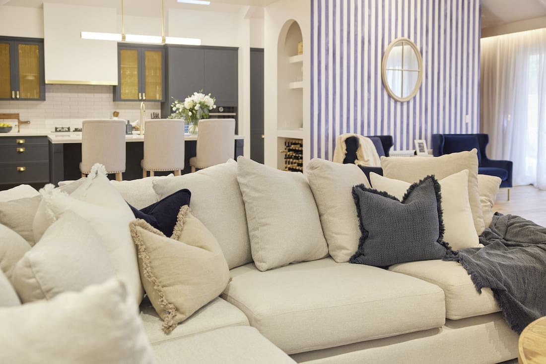 Couch with extra cushions and blue striped wall
