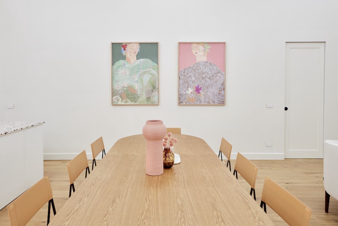 Pill shaped extra long dining table with twin artworks