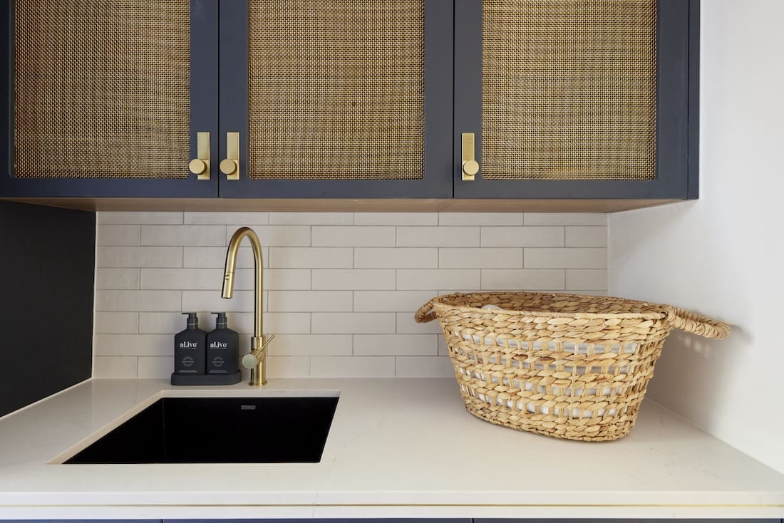 Brass inset panels in laundry cabinetry