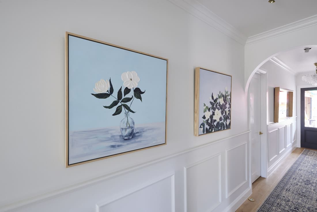 Artwork in hallway with wainscotting