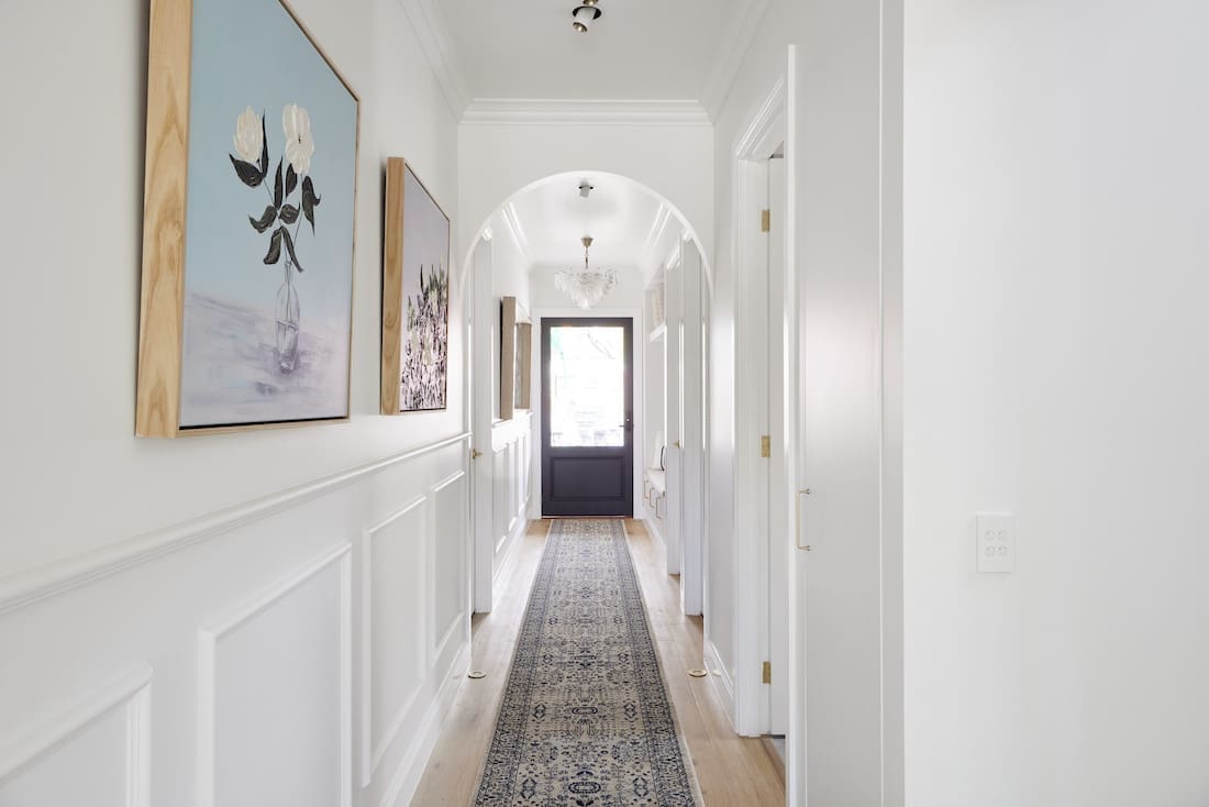 Hallway with arched doorways and wainscotting