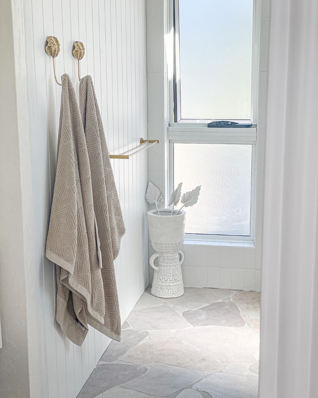 White bathroom with stone paving _ coastal ensuite makeover