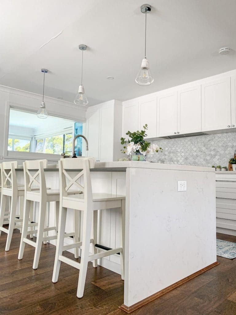 White kitchen bench with white bar stools