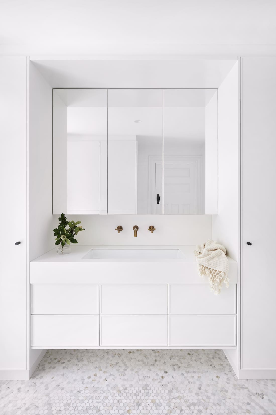 White bathroom with pennyround tile floors by The Stylesmiths