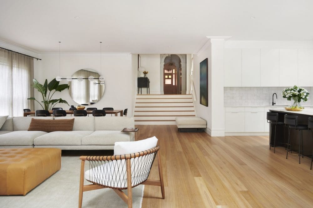 Open plan living dining and kitchen with wide staircase by The Stylesmiths