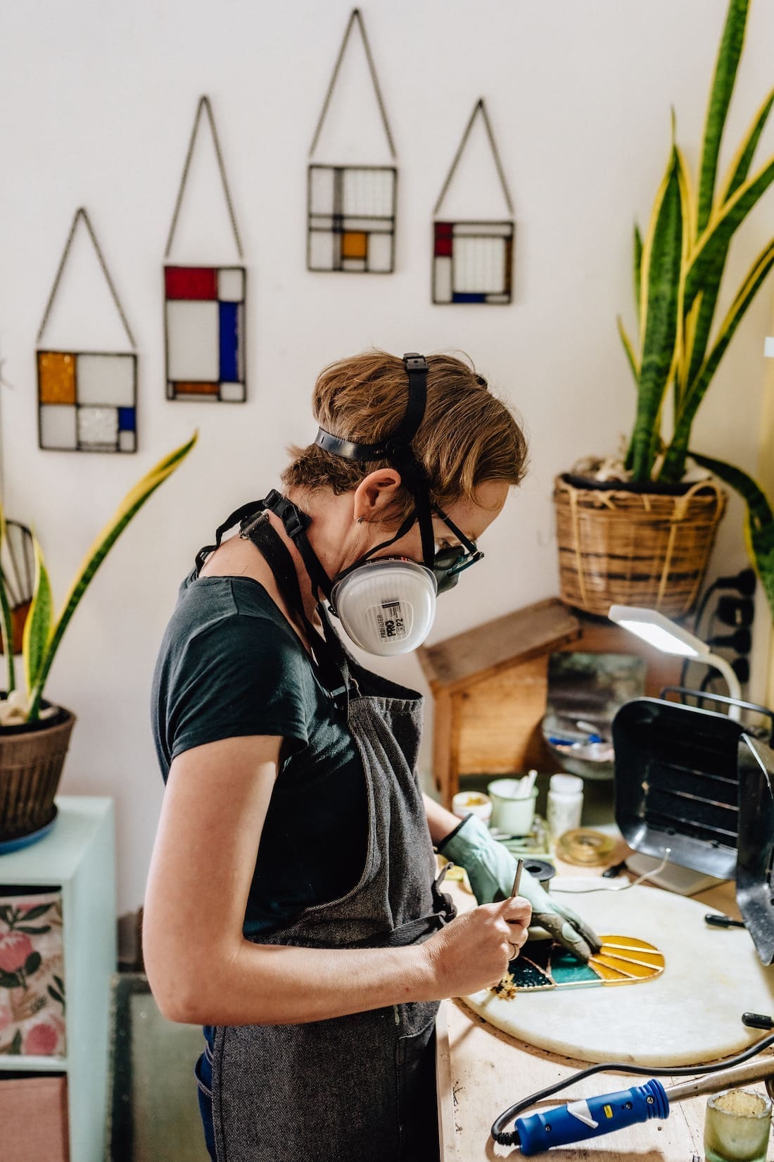Stained glass artist Ivy De Bruijn creating in her studio