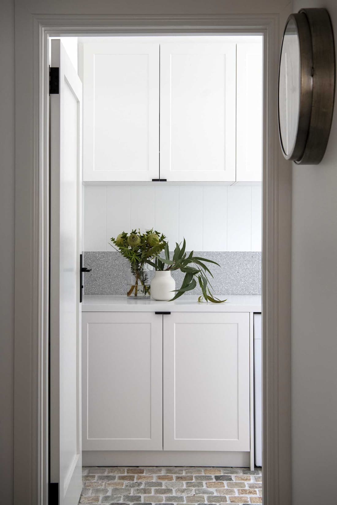 View through to laundry with cobblestone flooring