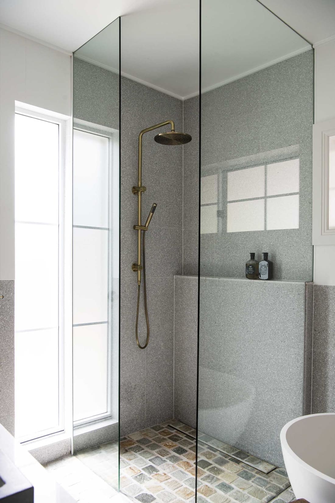 Glass shower with cobblestone floor