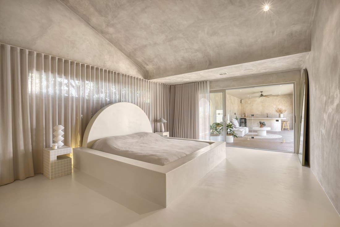 Curved bedhead in neutral bedroom in Ruin X house