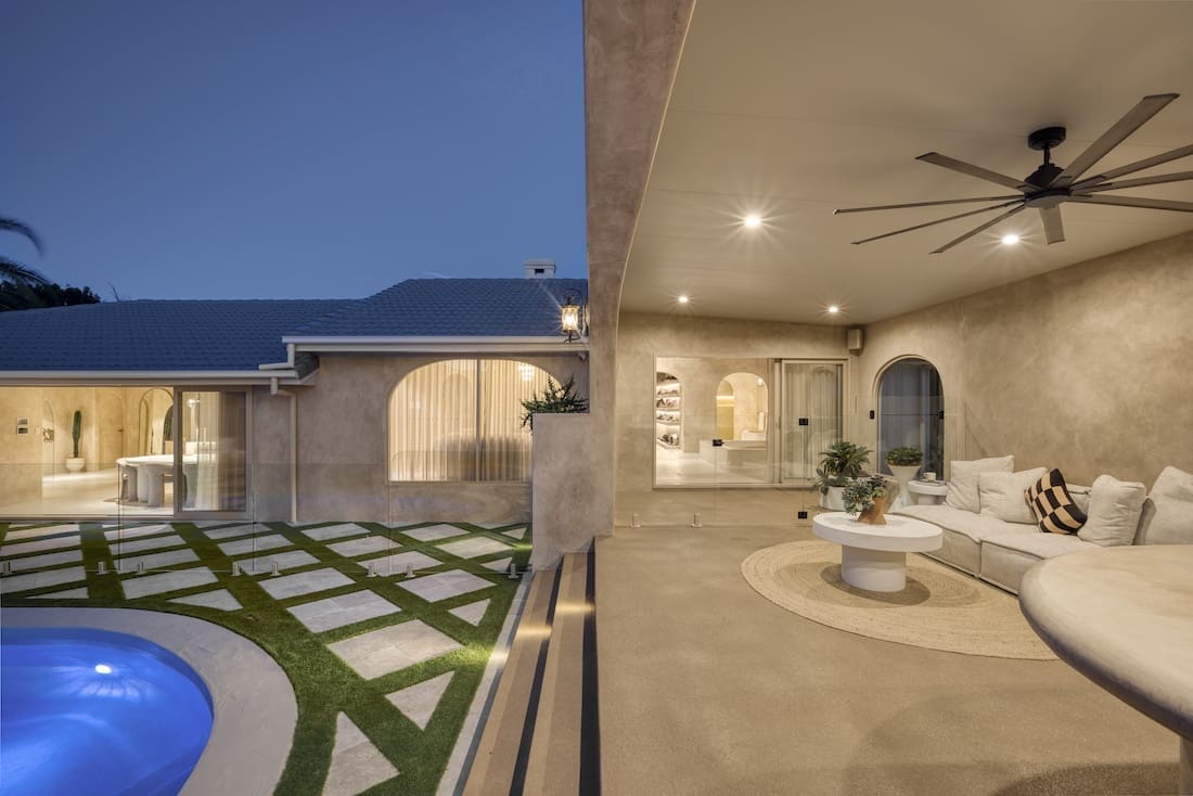 Outdoor living area with checkerboard pavers and grass at Ruin X