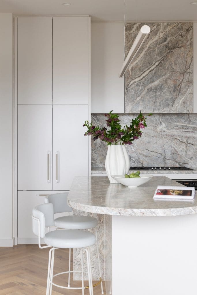 Integrated appliances in white and marble wrapped rangehood