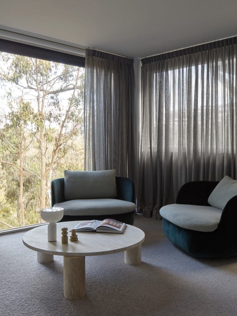 Living room with sheer curtains and view of trees