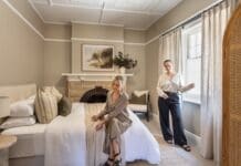 Alisa and Lysandra in bedroom of their coastal heritage Tudor AirBnB