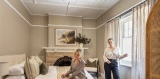 Alisa and Lysandra in bedroom of their coastal heritage Tudor AirBnB