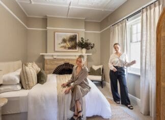 Alisa and Lysandra in bedroom of their coastal heritage Tudor AirBnB
