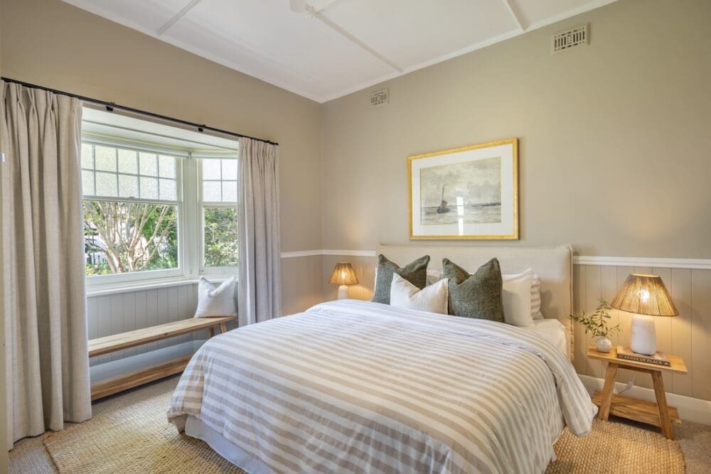 Bedroom with striped bedding in Alisa and Lysandra coastal heritage Tudor AirBnB