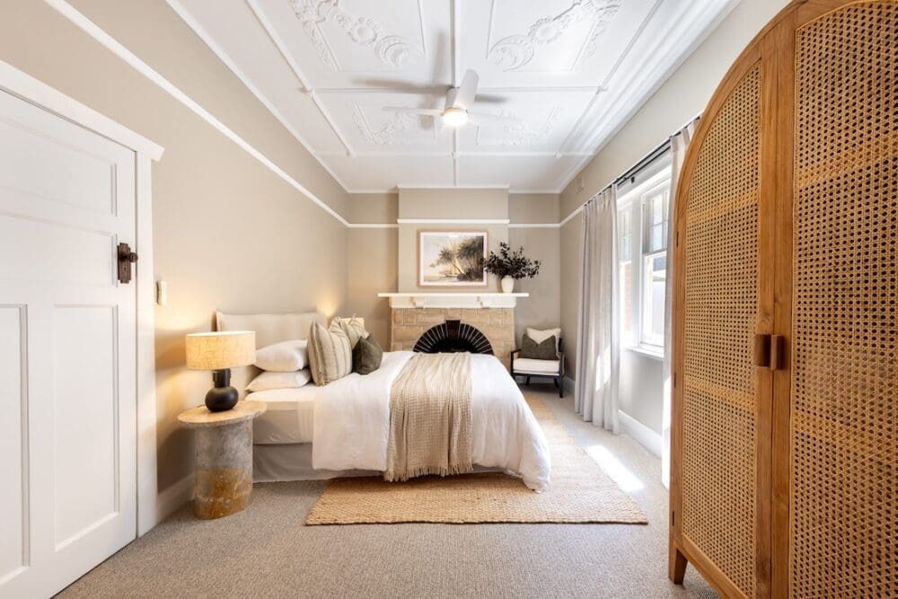 Bedroom with rattan cabinet inside Alisa and Lysandra coastal heritage Tudor AirBnB