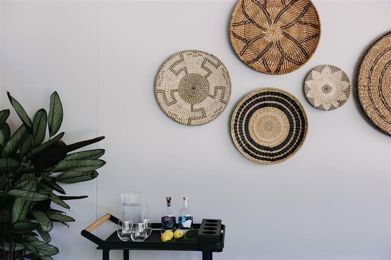 Bar cart with woven baskets on wall as decor
