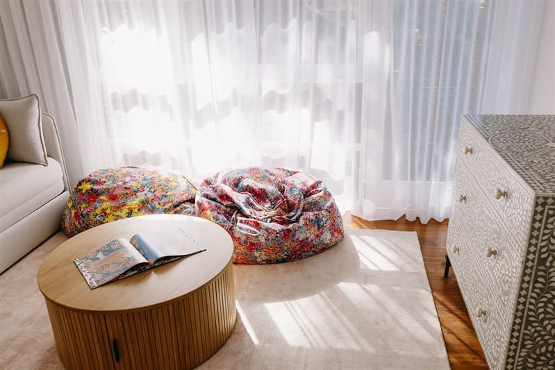 Round coffee table with hidden storage and colourful Kip and Co beanbags