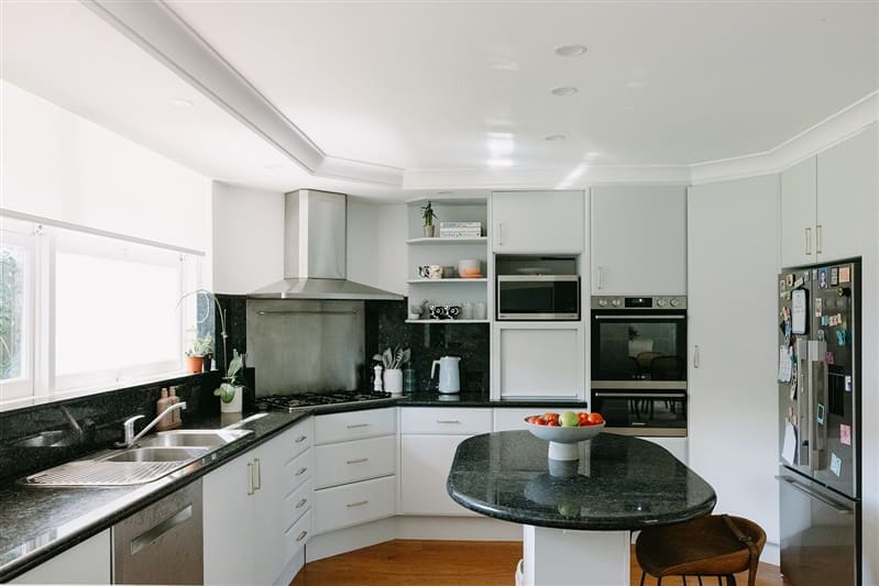Dark counter top kitchen with curved island bench