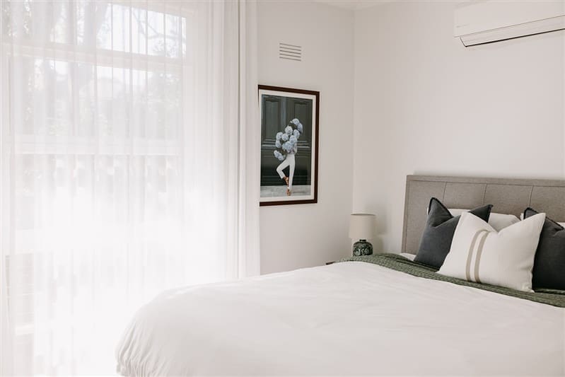 Simple styling in master bedroom with hydrangea artwork