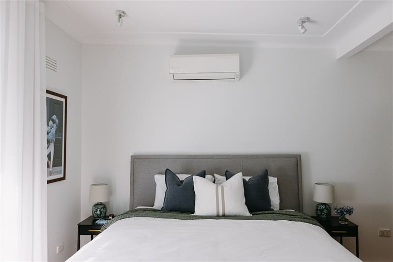 Simple bedroom styling with grey bedhead and blue cushions
