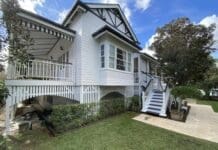 Queenslander home painted white with grey trim