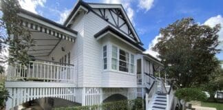 Queenslander home painted white with grey trim