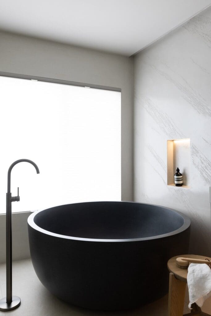 Round black bath with stand alone gooseneck tap