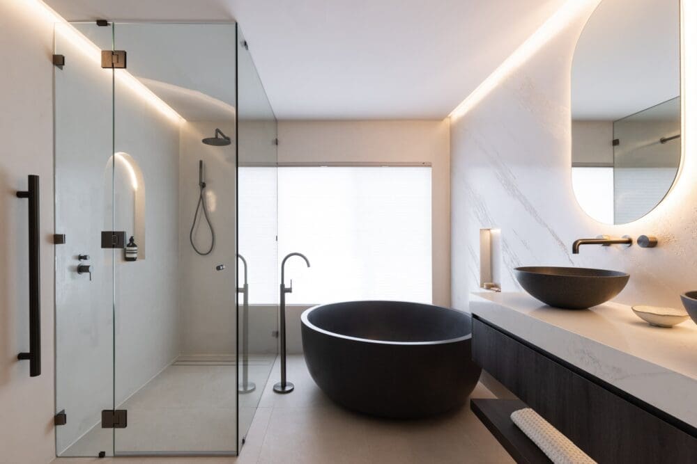 Black and white bathroom with round black bath