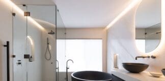 Black and white bathroom with round black bath