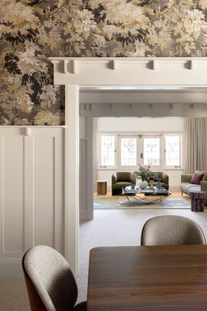 Dining room with floral wallpaper through to living room at House 1915