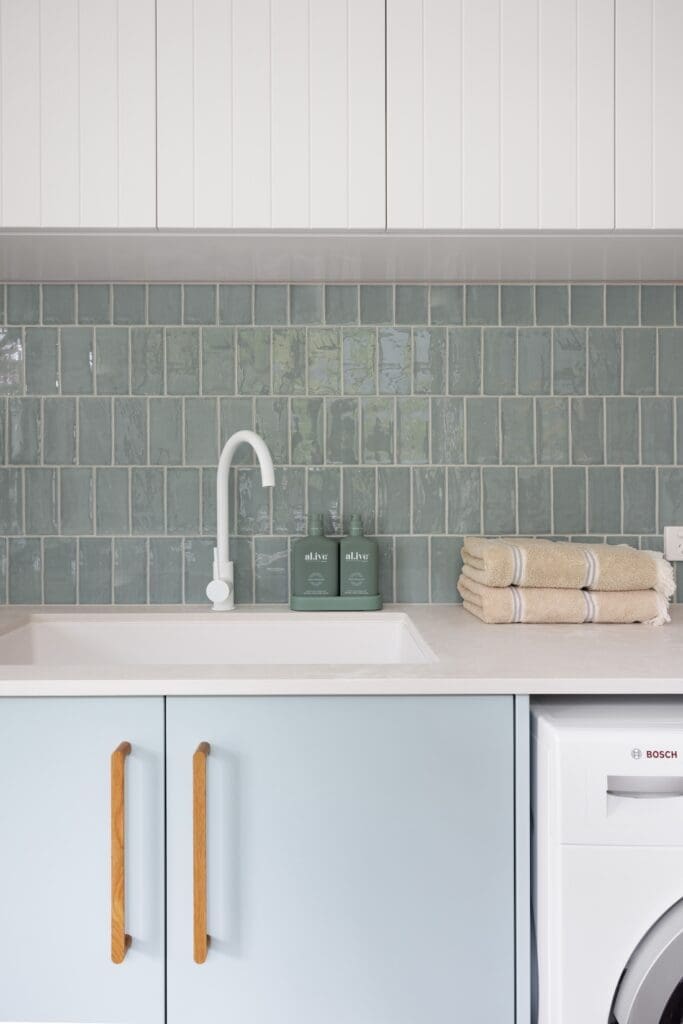 Blue backsplash in laundry with blue cabinetry