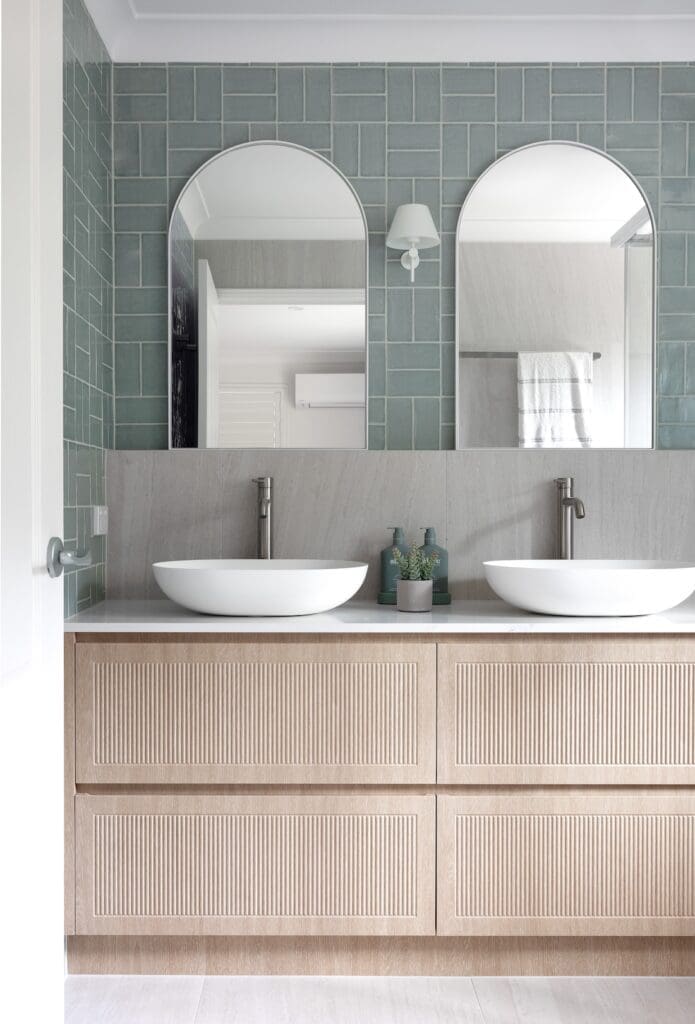 Double arch mirror and basin in blue bathrom