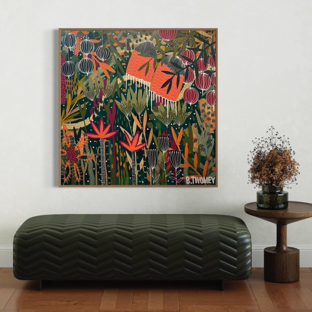 Colourful botanical artwork from B Twomey above a green fabric ottoman