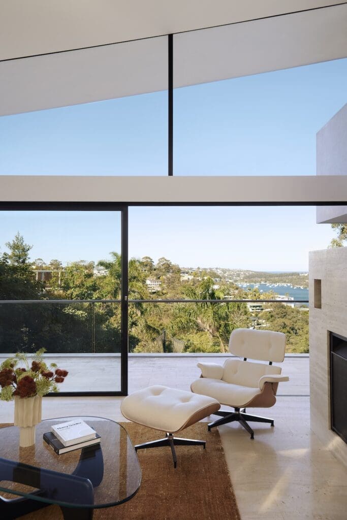 Eames lounge chair next to travertine fireplace in Meller House