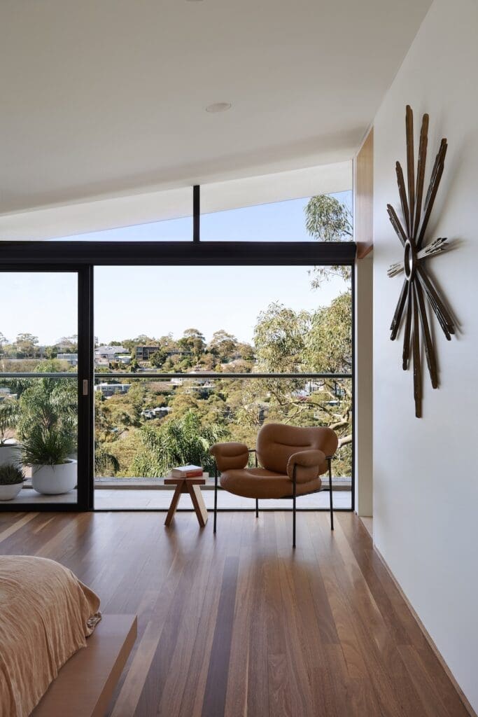 Occasional chair against floor to ceiling glass window in master bedroom