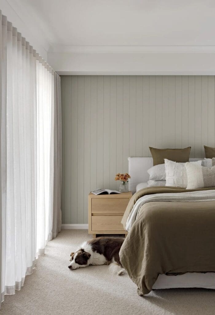 Master bedroom with green feature wall in Ewingsdale home