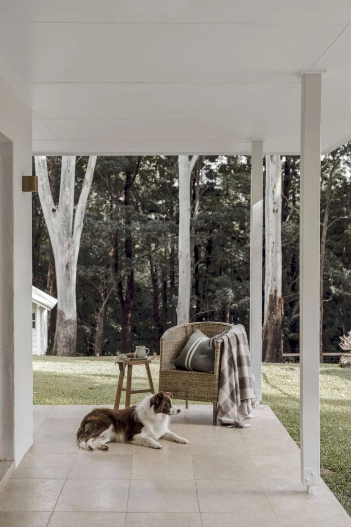 Ewingsdale home front porch with chair and dog