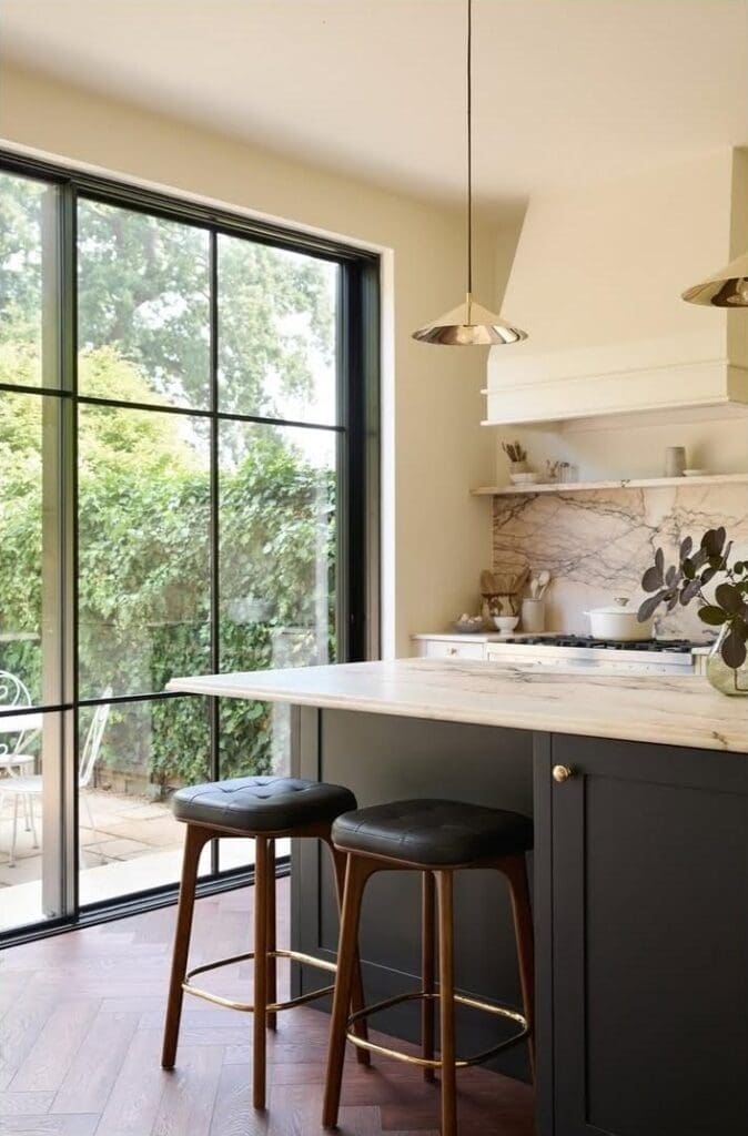 Marble kitchen renovation black island bench and floor to ceiling glass doors
