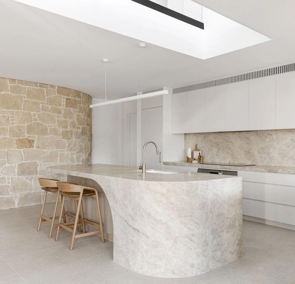 Kitchen island skylight and natural stone wall in kitchen at The Stables Burraneer House