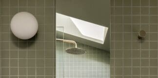 White pedestal basin in green grid tile bathroom