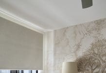 A whimsical forest inspired nursery room tour White side table and feeding chair in nursery